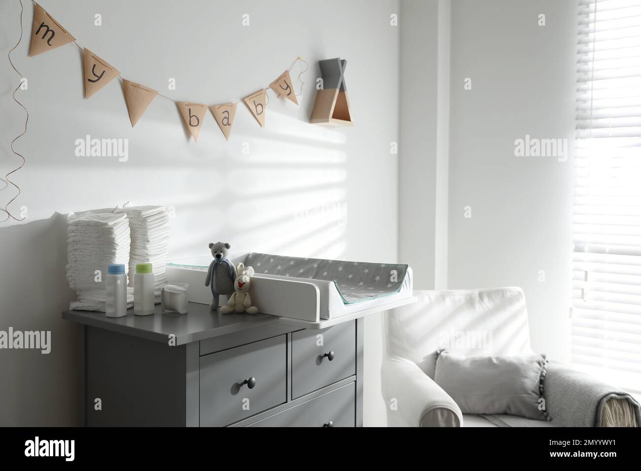 Chest of drawers with changing tray and pad in baby room. Interior