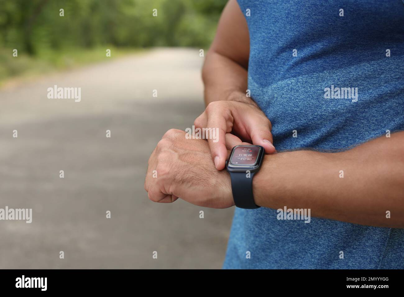 Man with smart watch checking time interval, distance, heart rate and