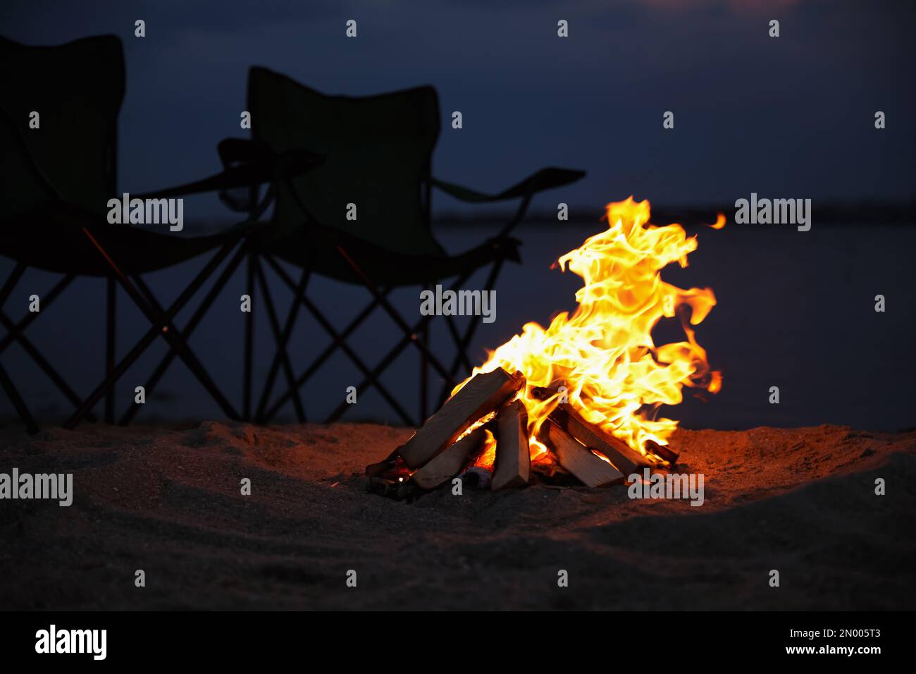 Beautiful bonfire with burning firewood on beach Stock Photo