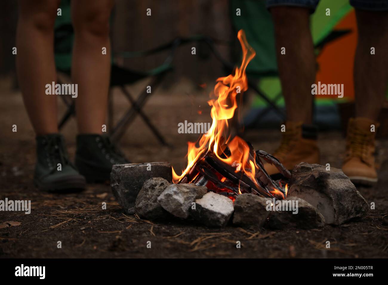 People near bonfire with burning firewood outdoors, closeup Stock Photo ...