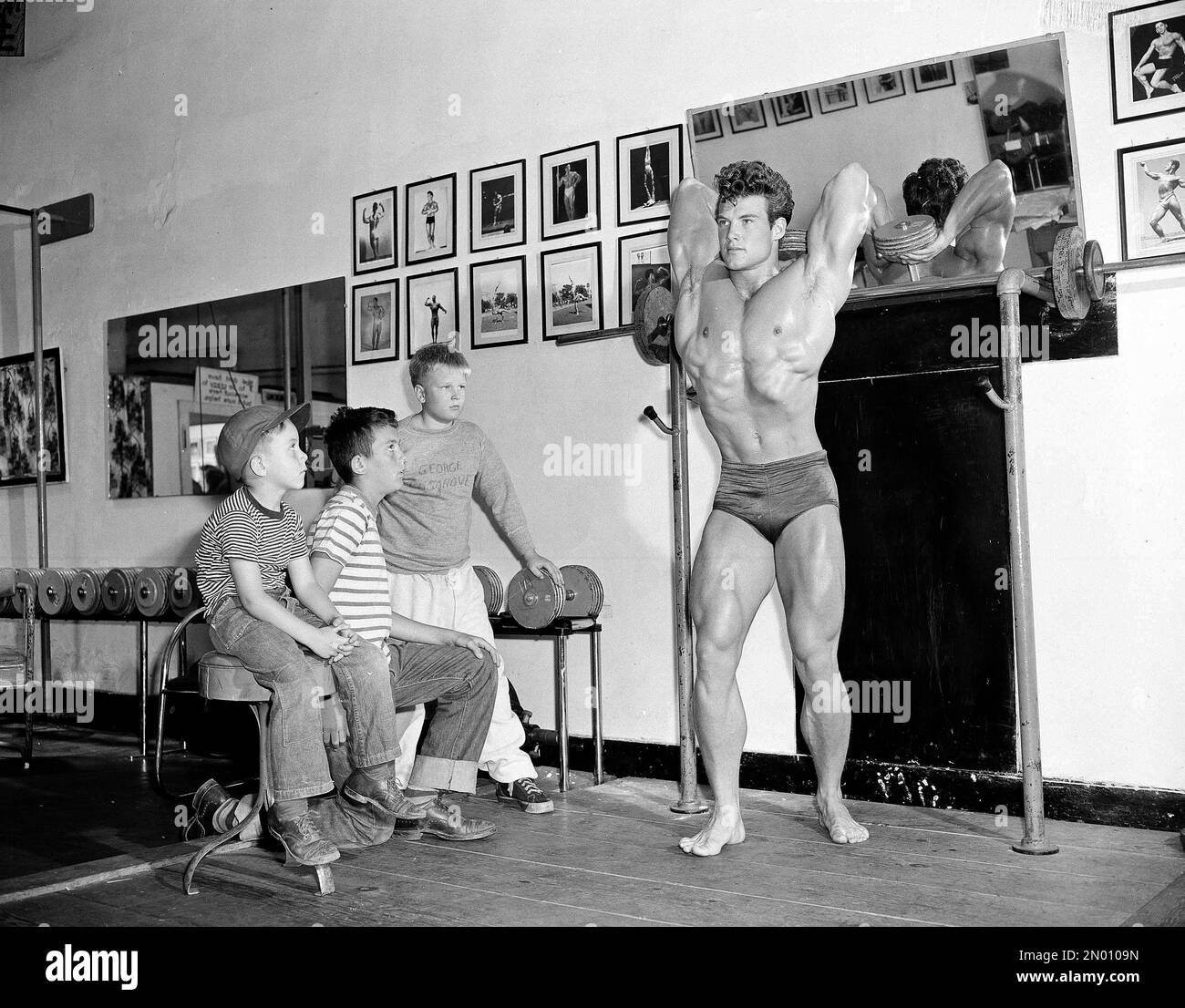 Bodybuilder Steve Reeves, 21, works out with weights in Ed Yarick's ...