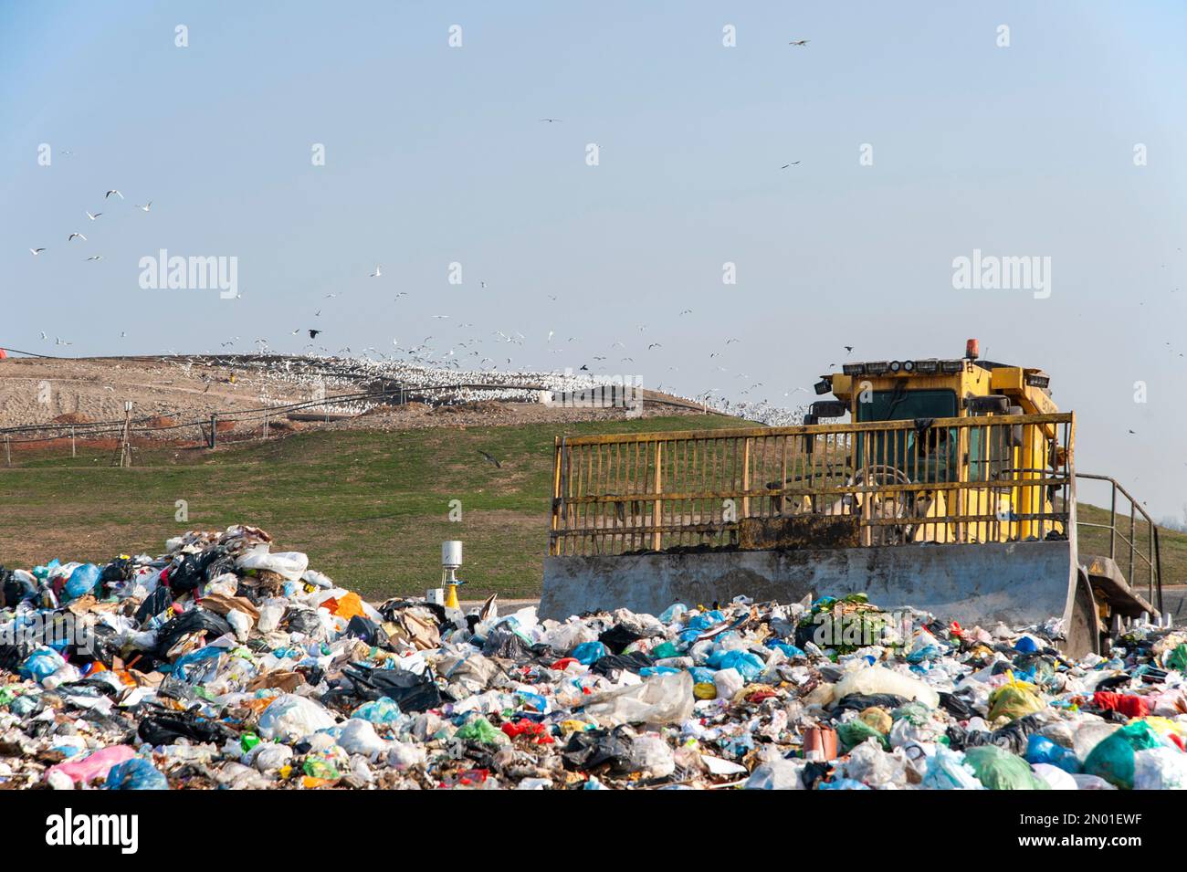 Municipal waste landfill. Workers with trucks and bulldozers at work in