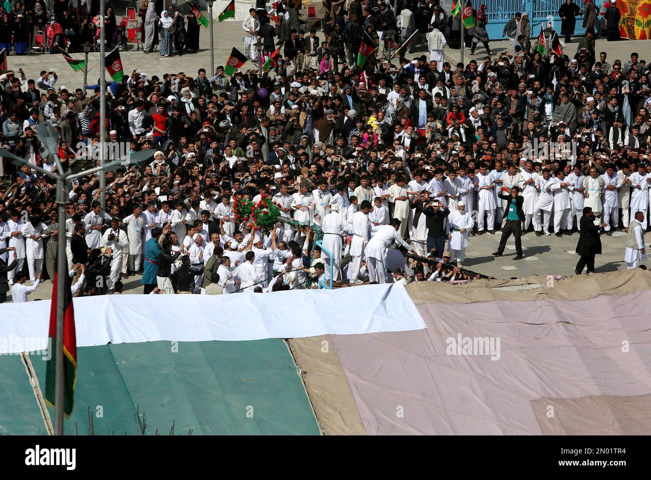 Afghan men raise the holy mace during Nowruz, at the KarteSakhi