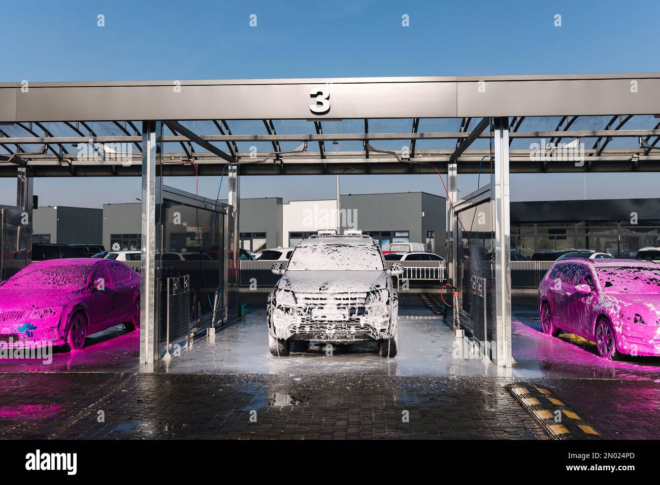 Different cars on self car wash. Layer of foam on the car. Pink and