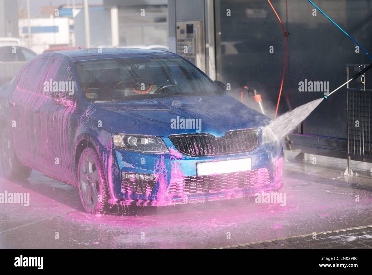 Process of man washing his car in a selfservice car wash station Stock