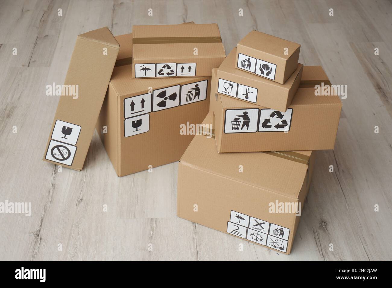 Cardboard boxes with different packaging symbols on floor. Parcel