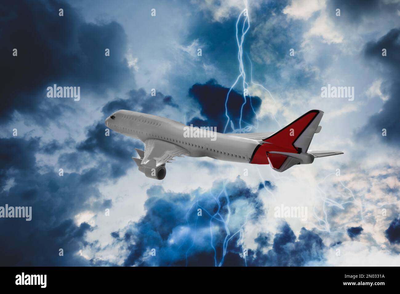 Airplane flying in cloudy sky during thunderstorm Stock Photo Alamy