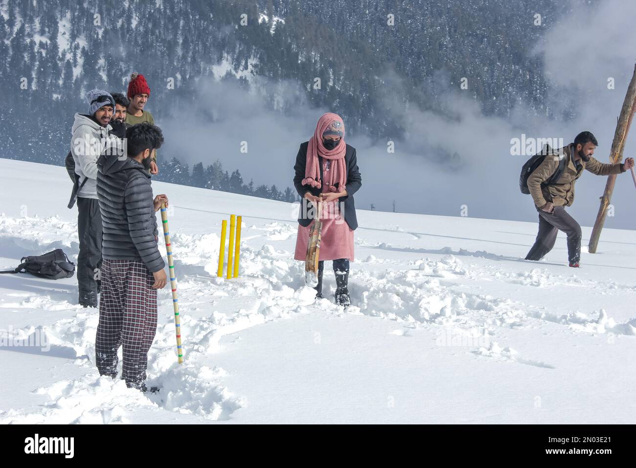A Girl Playing Snow Cricket at forest glades of Nagmarg area of North Kashmir's Bandipora  district, Jammu & Kashmir India Stock Photo
