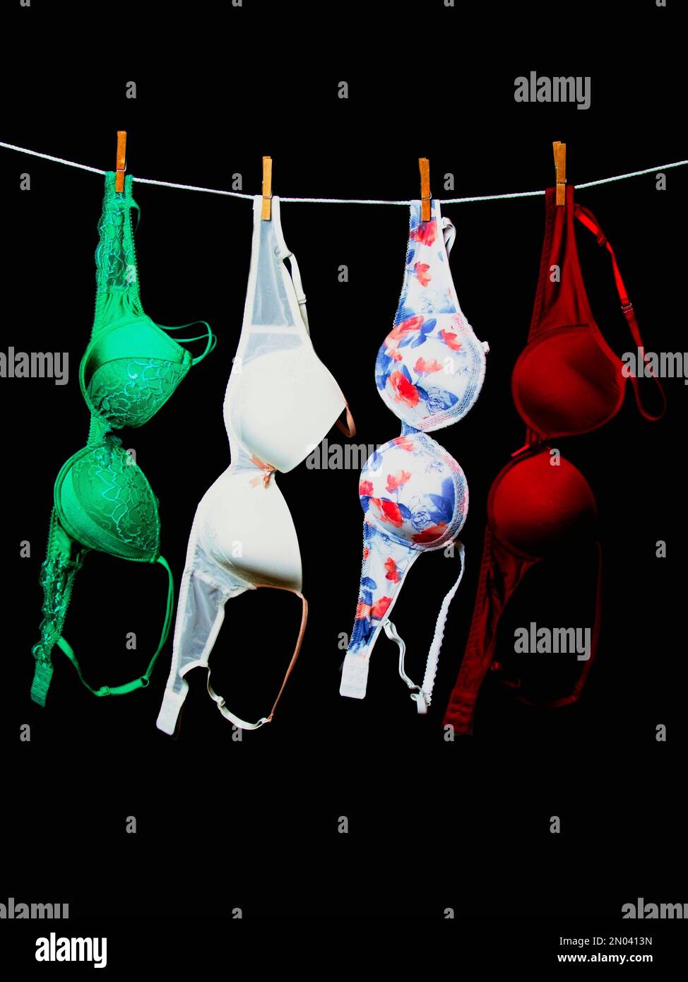Colorful women's bras on a string and a black background Stock
