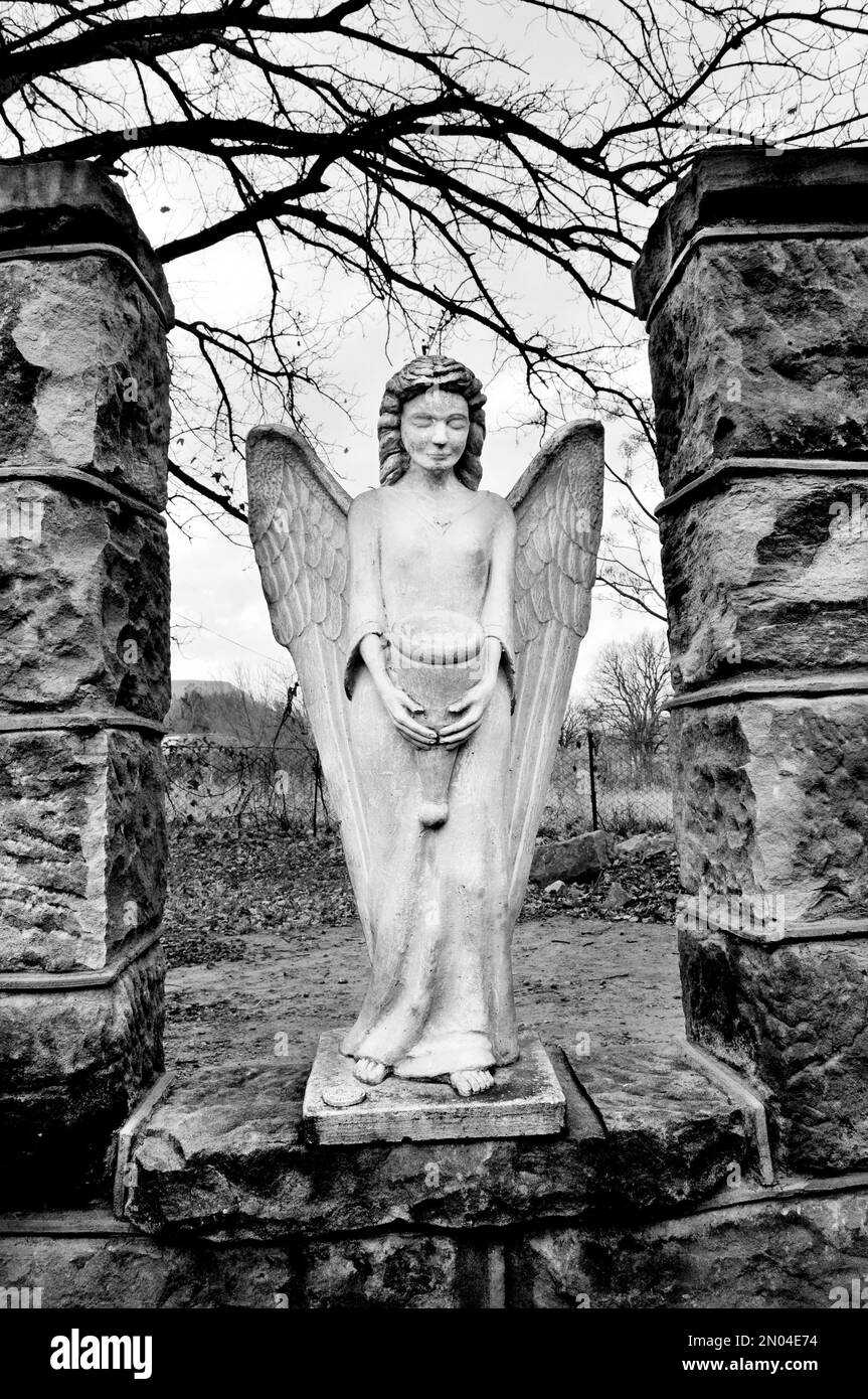 A vertical black and white shot of an angel statue Stock Photo