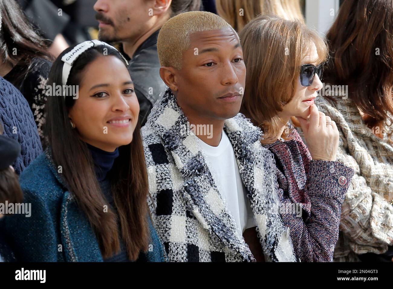 From left, Helen Lasichanh, Pharrell Williams, and French actress Isabelle  Huppert attend the Chanel's Fall-winter 2016-2017 ready to wear collection  presented in Paris, France, Tuesday, March 8, 2016. (AP Photo/Francois Mori  Stock
