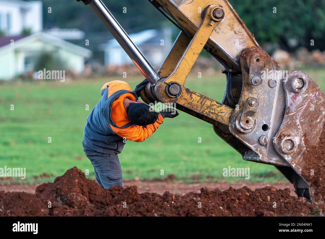 Excavator maintenance and repair operator doing repairs and maintenance. Stock Photo