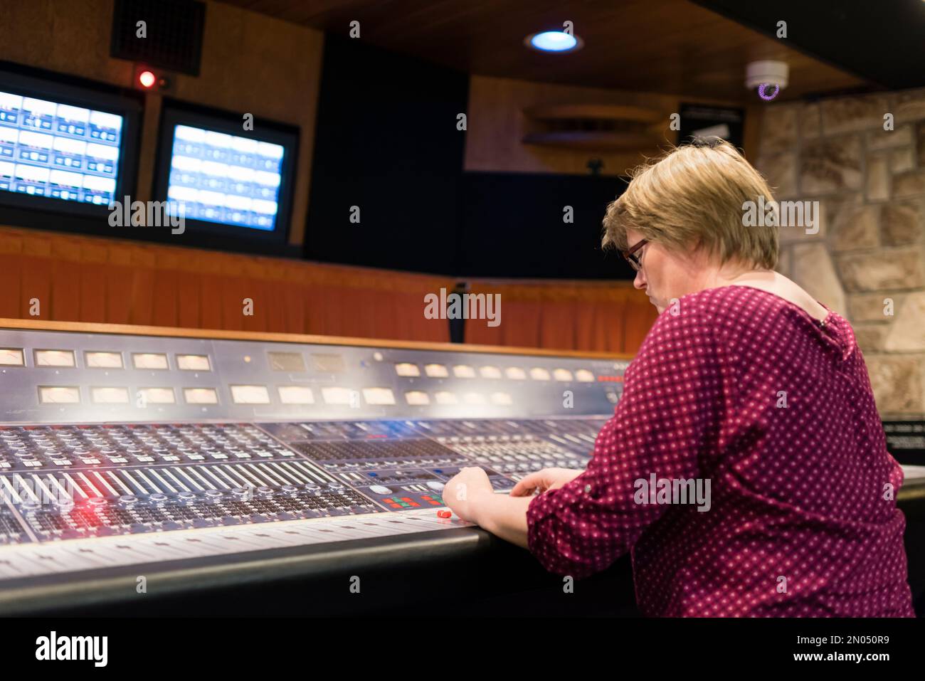 A woman is sitting in a professional analog vintage audio recording studio. Picture taken at the Mountain View Studio at Montreux, Switzerland. Stock Photo