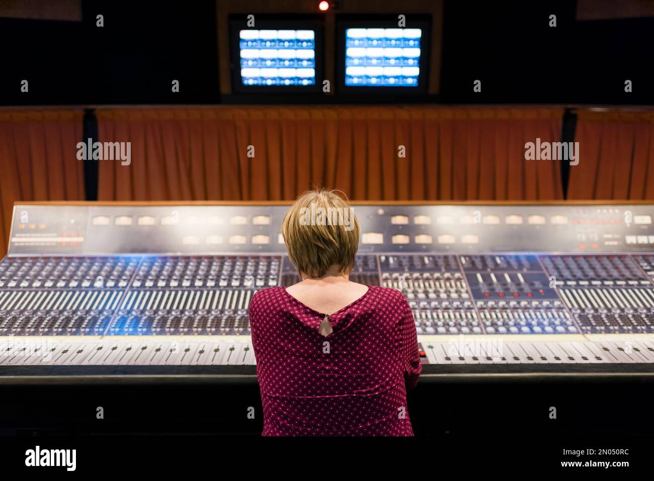 A woman is sitting in a professional analog vintage audio recording studio. Picture taken at the Mountain View Studio at Montreux, Switzerland. Stock Photo