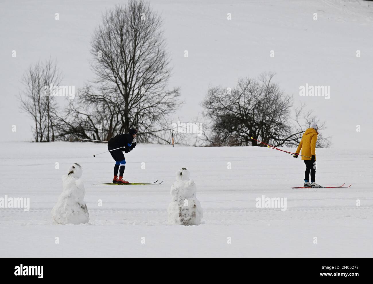 Oberammergau, Germany. 05th Feb, 2023. Crosscountry skiers warm up next to snowmen on the trail