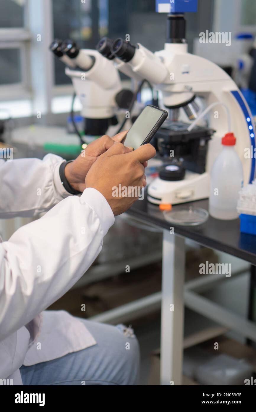 Close-up of a scientist using a cell phone in the laboratory Stock Photo