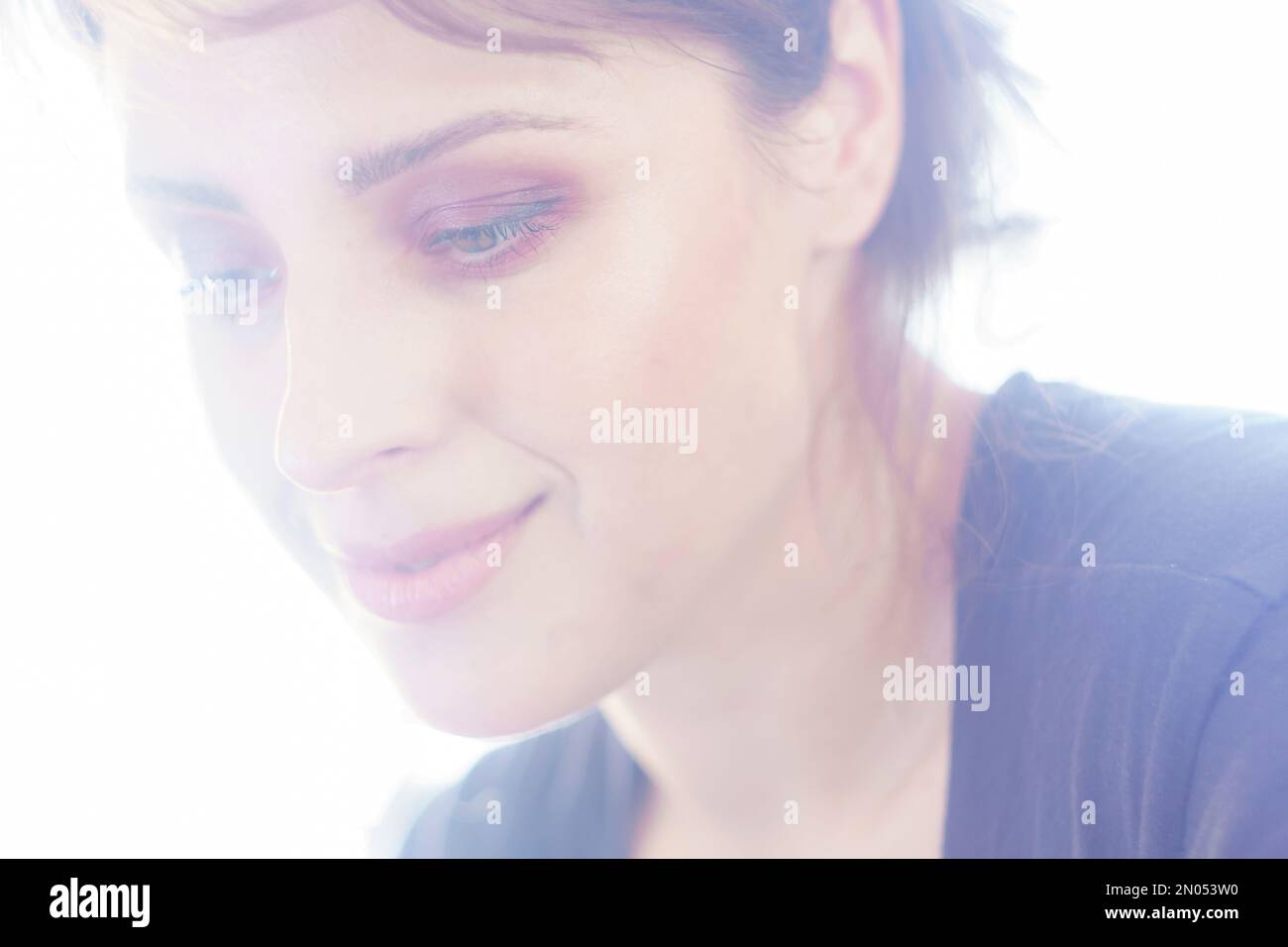 Overexposed portrait of a woman with tender smile wearing glittery red