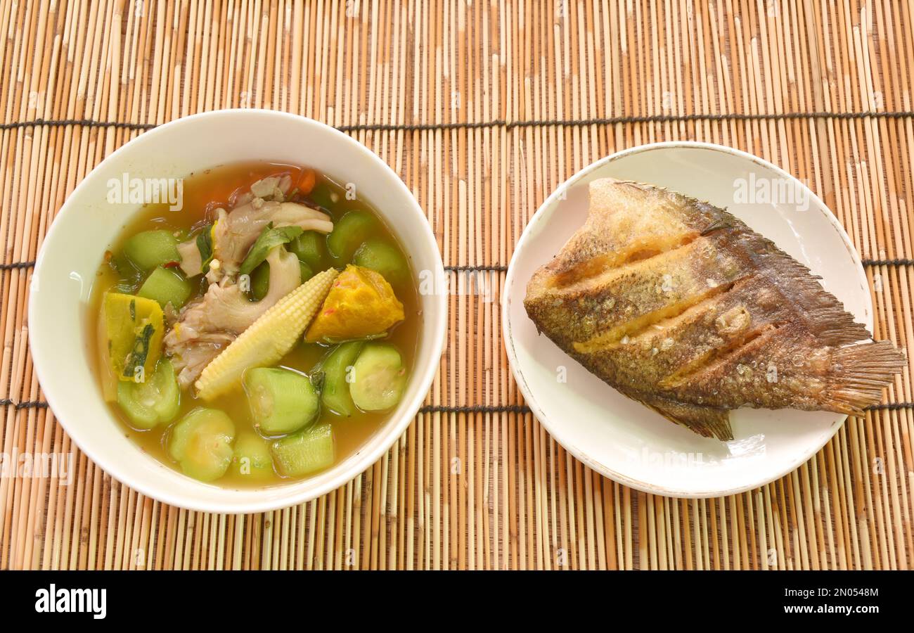 boiled spicy mixed vegetable curry soup on bowl with deep fried snake skin catfish or gourami on dish Stock Photo