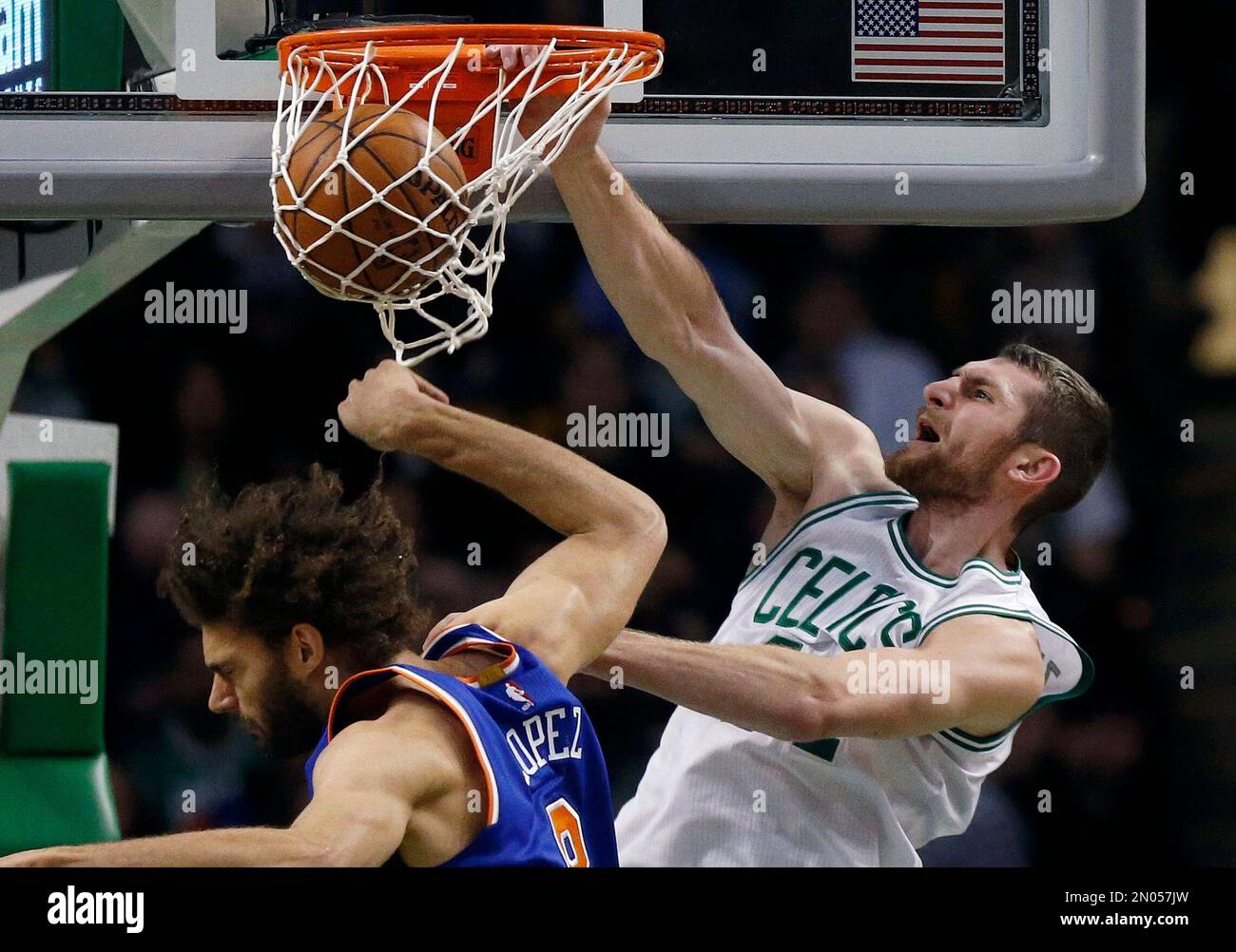 Boston Celtics' Tyler Zeller, right, dunks above New York Knicks' Robin