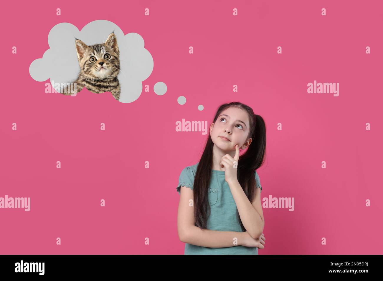 Little girl on pink background dreaming about cute kitten Stock Photo Alamy