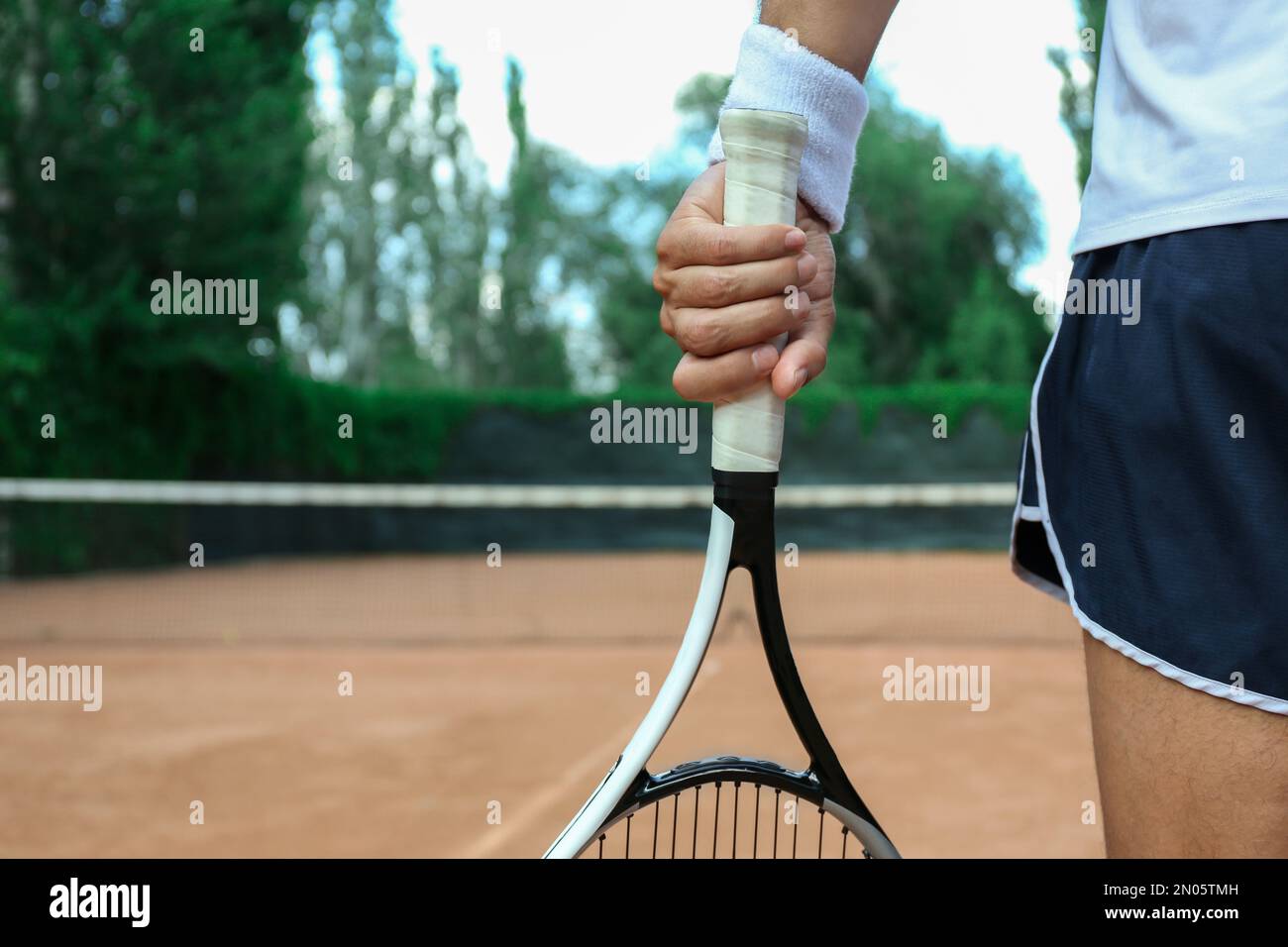 Sportsman with racket at tennis court, closeup Stock Photo - Alamy