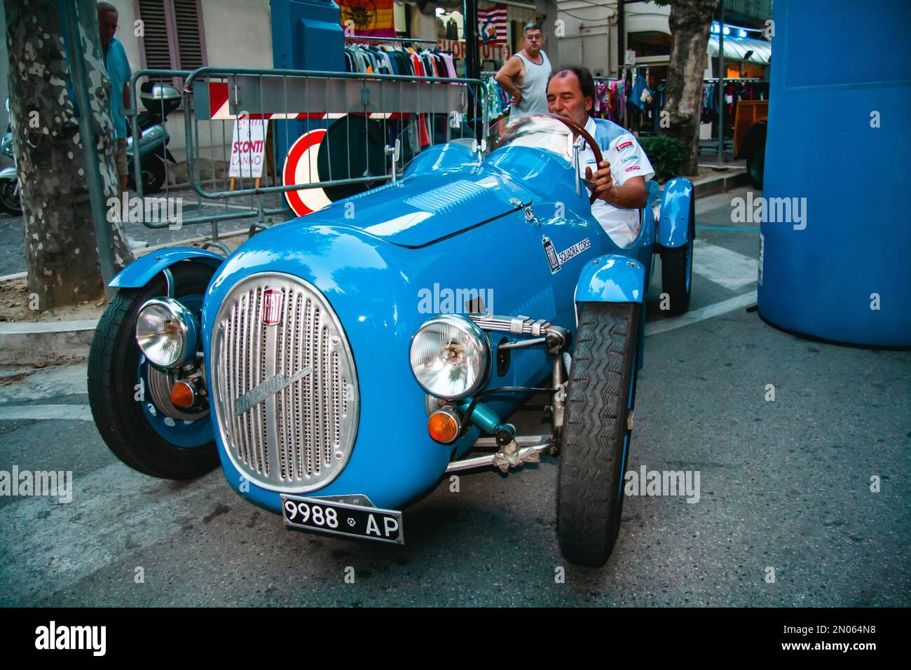 Vintage car at an outdoor event. An italian blue Fiat 500A Barchetta at an event for car collectors. A man driving a vintage Fiat 500 A Barchetta Stock Photo