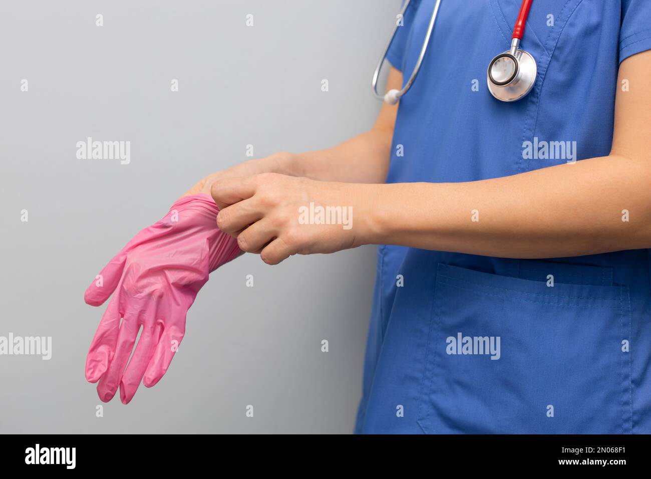 doctor in the hospital puts on a glove. doctor wear gloves. doctor puts on rubber gloves. doctor works. Stock Photo