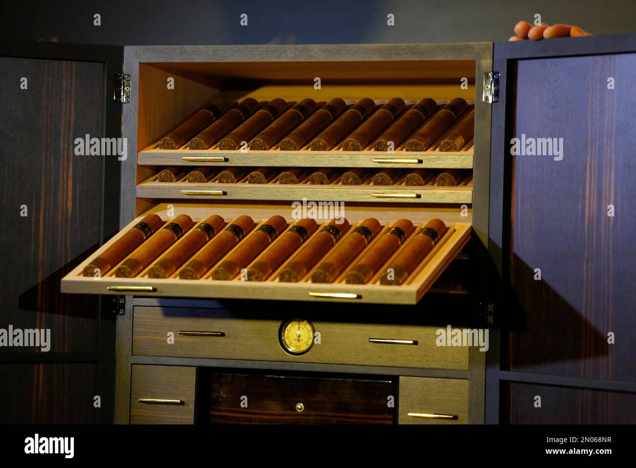 Cigars lay inside of a humidor made with panels of 24karat goldplated