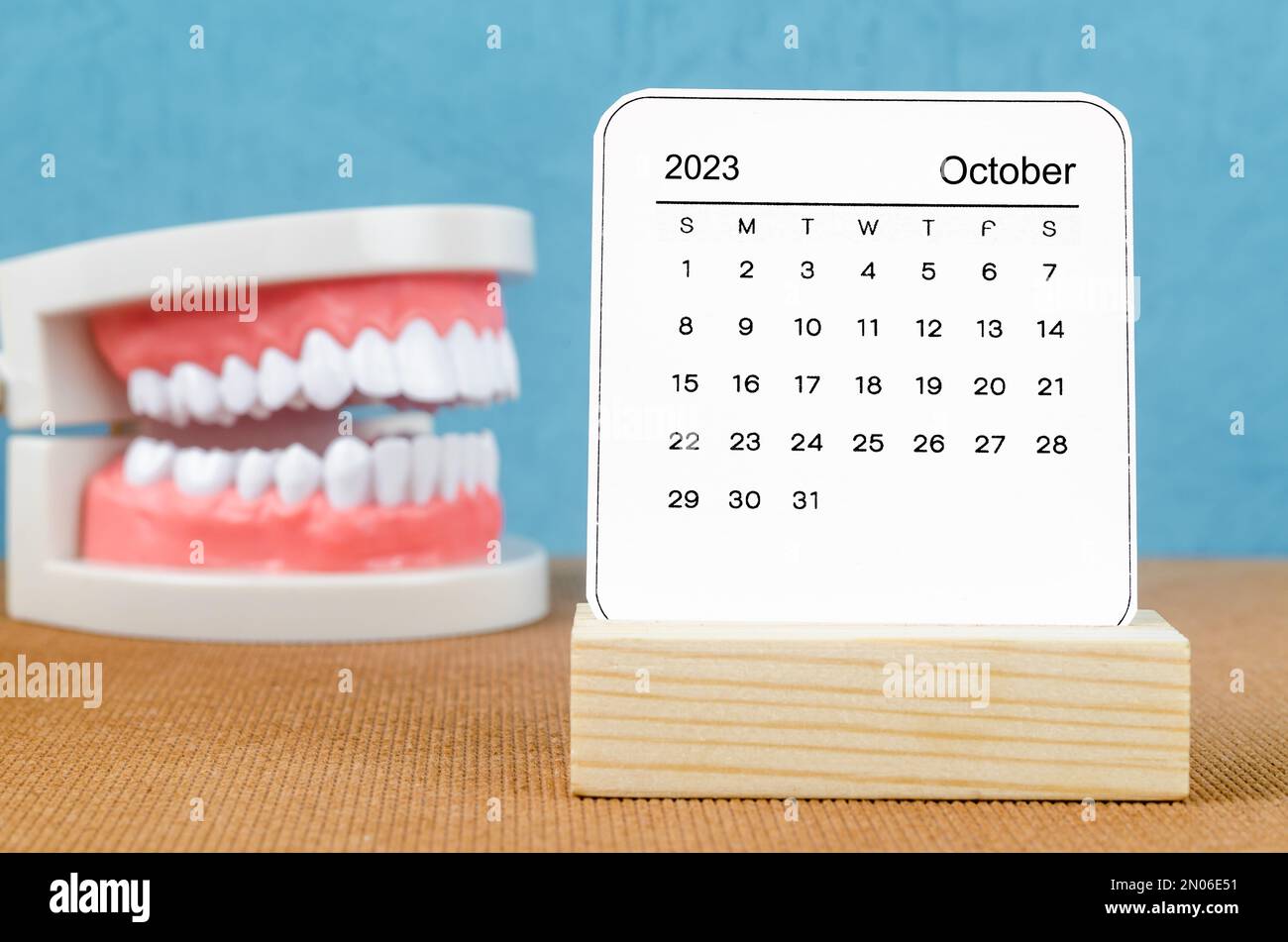October 2023 Monthly calendar for 2023 year with Model tooth on wooden ...