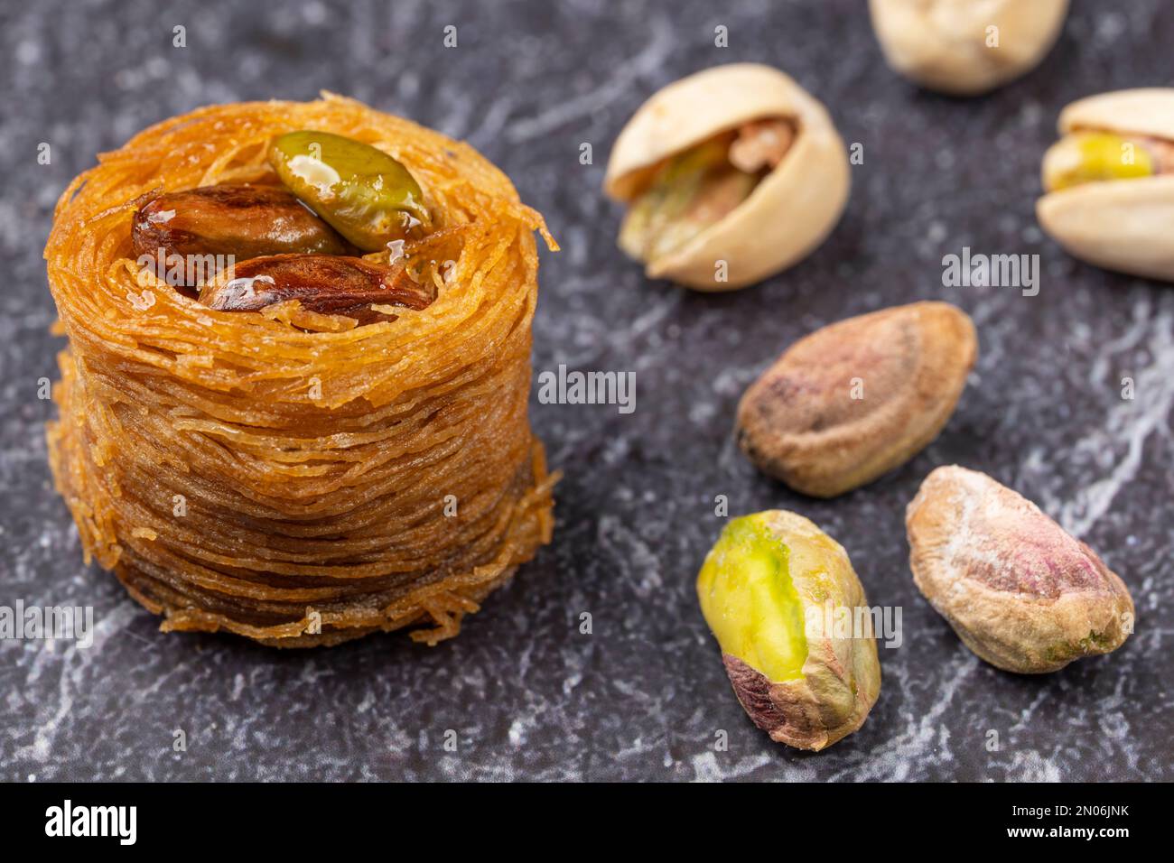 Close up of angel hair nest with caramelized pistachios. Arranged on a slate plate and decorated with pistachios Stock Photo