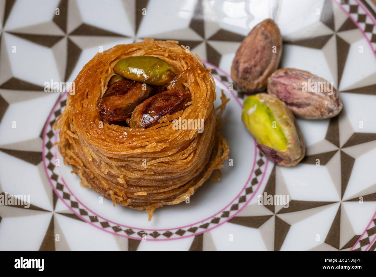 Close-up of an angel hair nest with caramelized pistachios. Arranged on a small plate and decorated with pistachio nuts Stock Photo