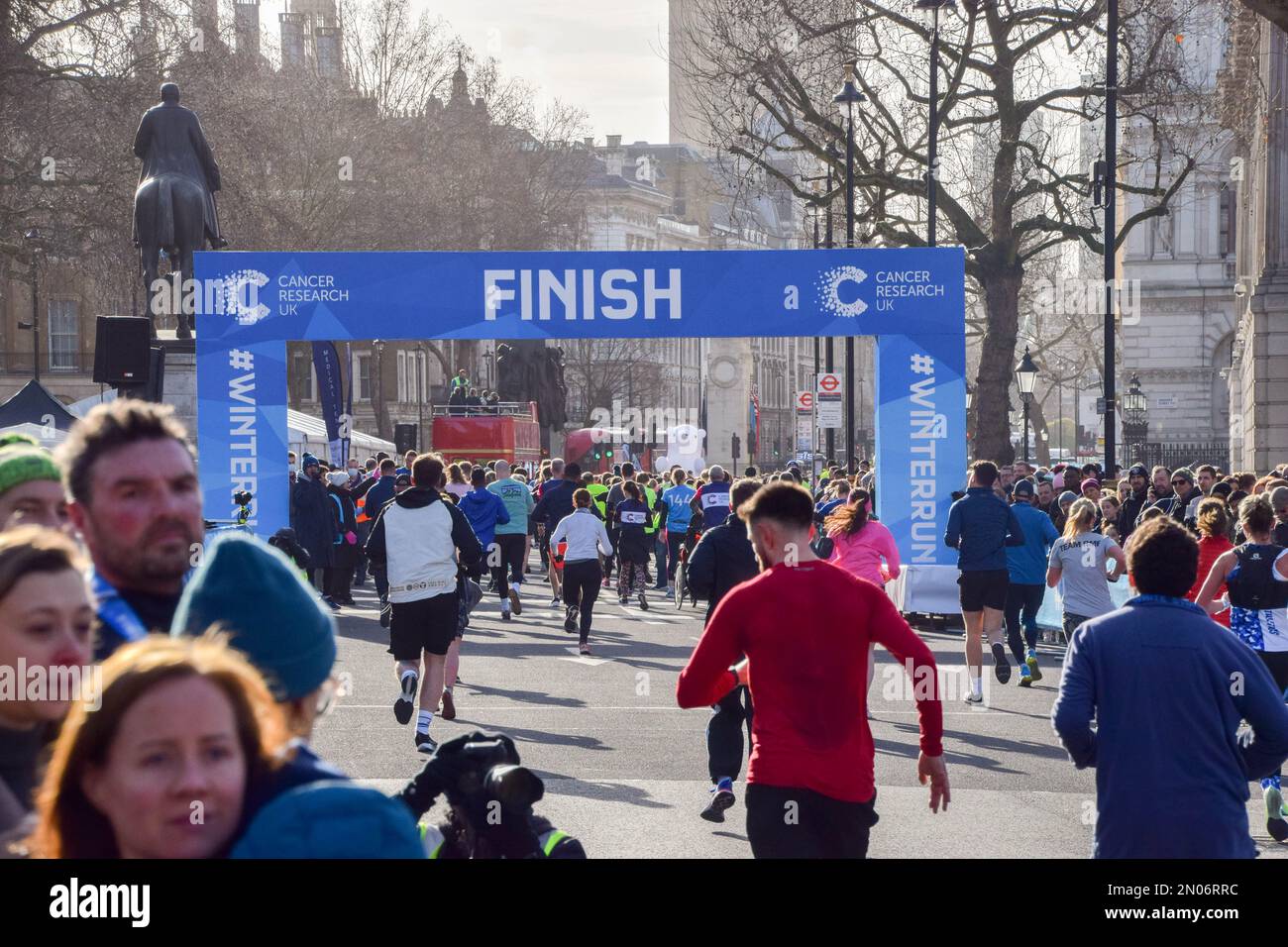 London, UK. 5th February 2023. Participants reach the finish line in Whitehall during this year's Cancer Research UK Winter Run in central London. Thousands of runners take part in the annual event raising funds for cancer research. Credit: Vuk Valcic/Alamy Live News Stock Photo