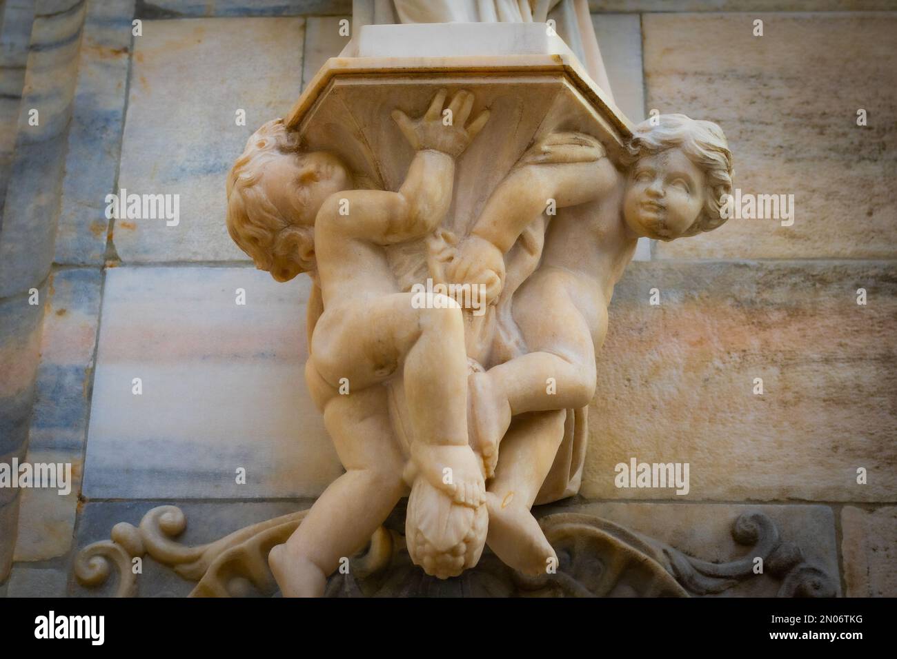 A Classical sculpture of two angels holding the column of a building ...