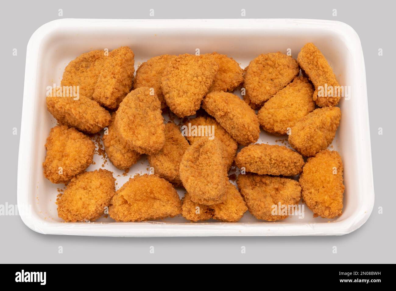 Precooked chicken nuggets in plastic food tray for supermarket sale , isolated on gray with