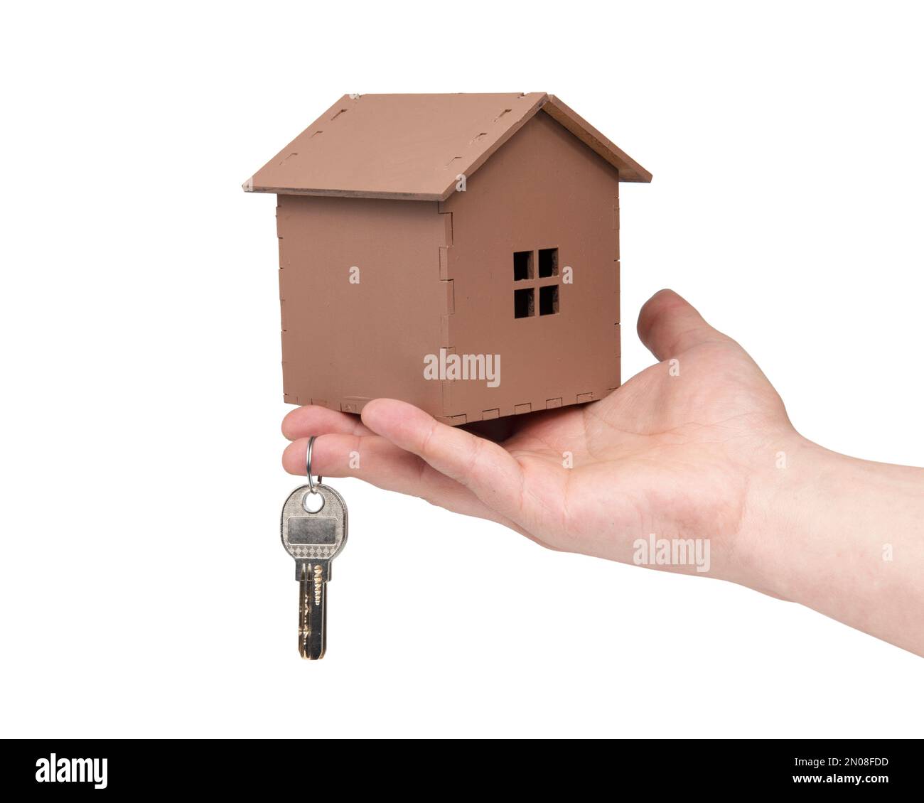 Hand holding keys and wooden house isolated on the white background ...