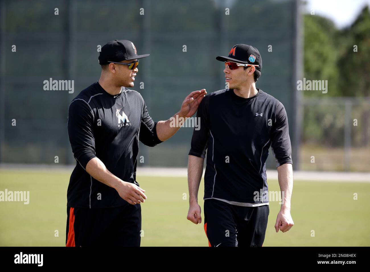 Miami Marlins' Giancarlo Stanton, left, talks with teammate Christian Yelich during spring training baseball practice Monday, Feb. 22, 2016, in Jupiter, Fla. (AP Photo/Jeff Roberson) Stock Photo