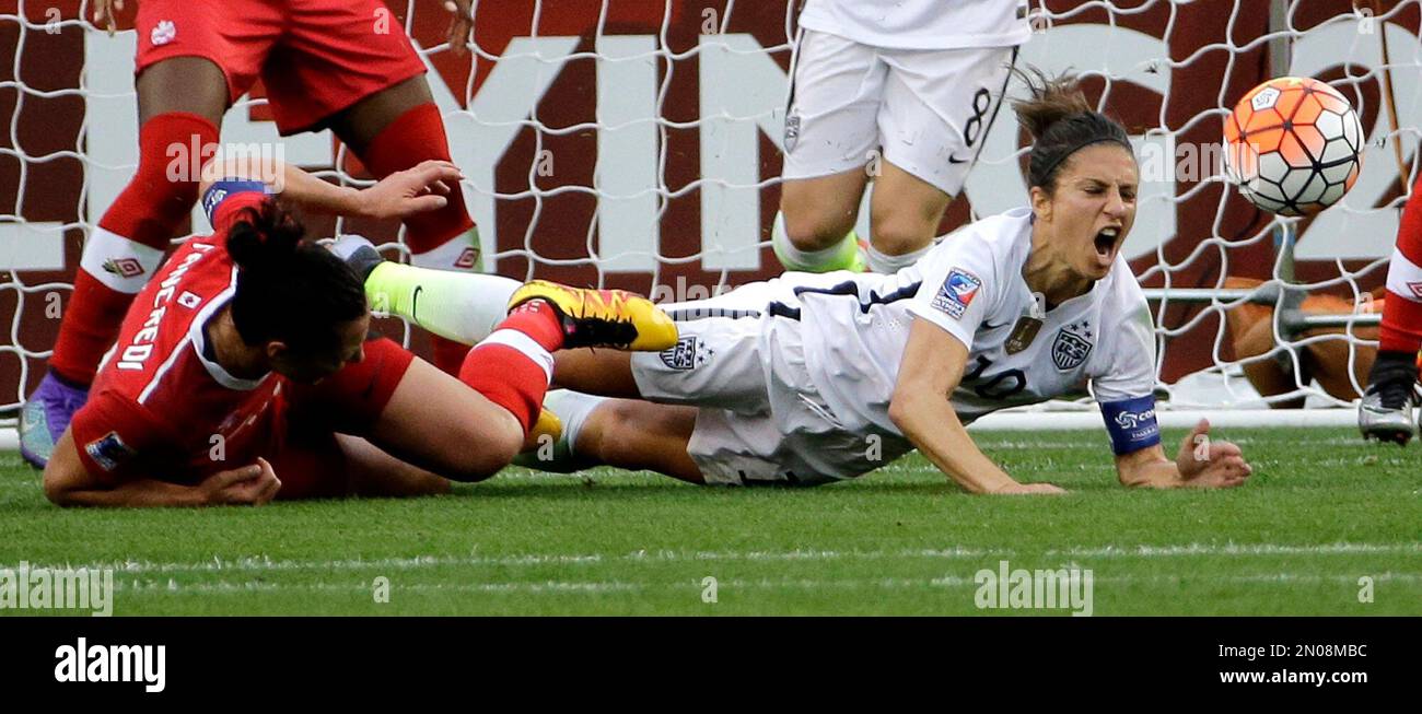 United States’ Carli Lloyd, right, falls with Canada's Melissa Tancredi