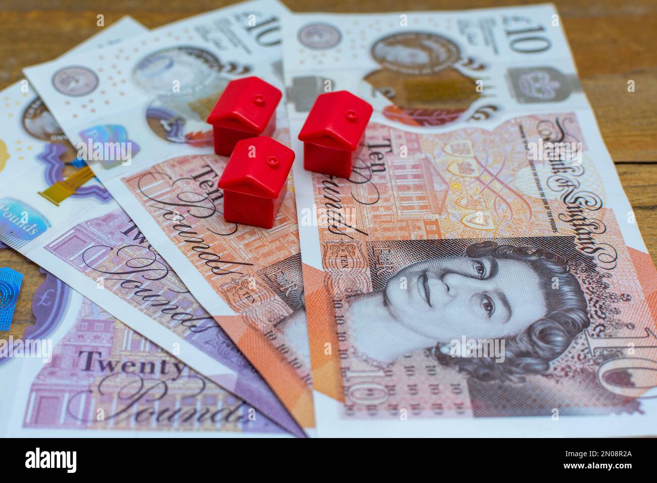 Houses on top of UK currency, a house price and mortgages concept. Stock Photo