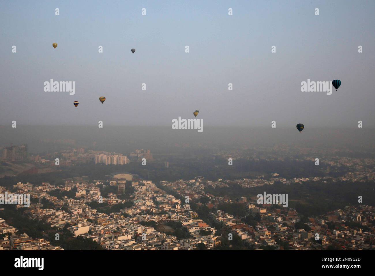 Hot air balloons are seen flying on the horizon over the Lucknow