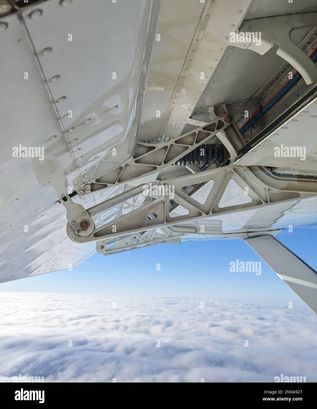 Detailed view of flaps , high-lift devices and actuators of a general aviation airplane flying at stall speed. Strut and wing of semi-cantilever high- Stock Photo