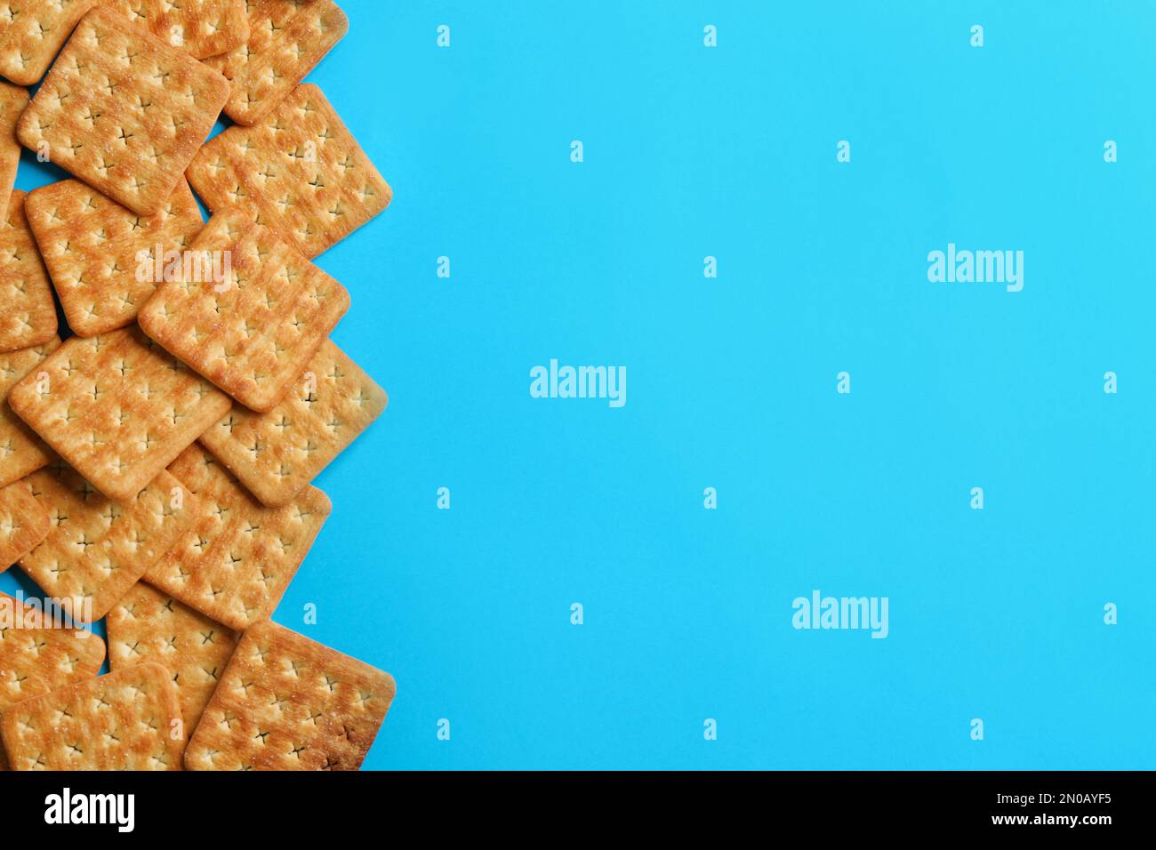 Delicious crackers on light blue background, flat lay. Space for text Stock Photo