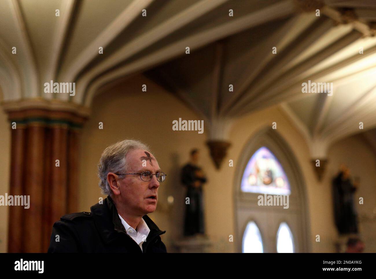 A churchgoer stands with ashes on his forehead during an Ash Wednesday