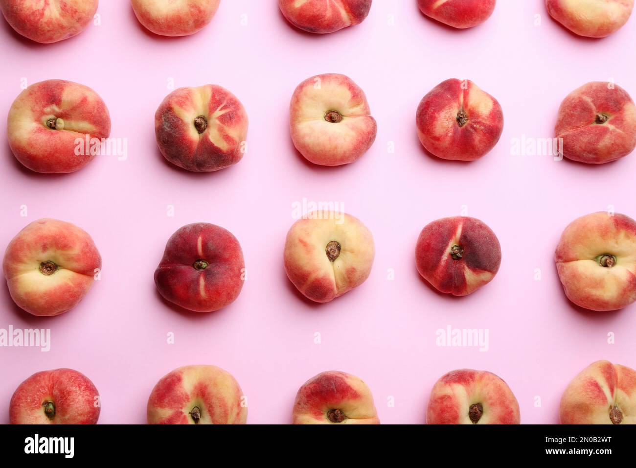 Fresh donut peaches on light pink background, flat lay Stock Photo