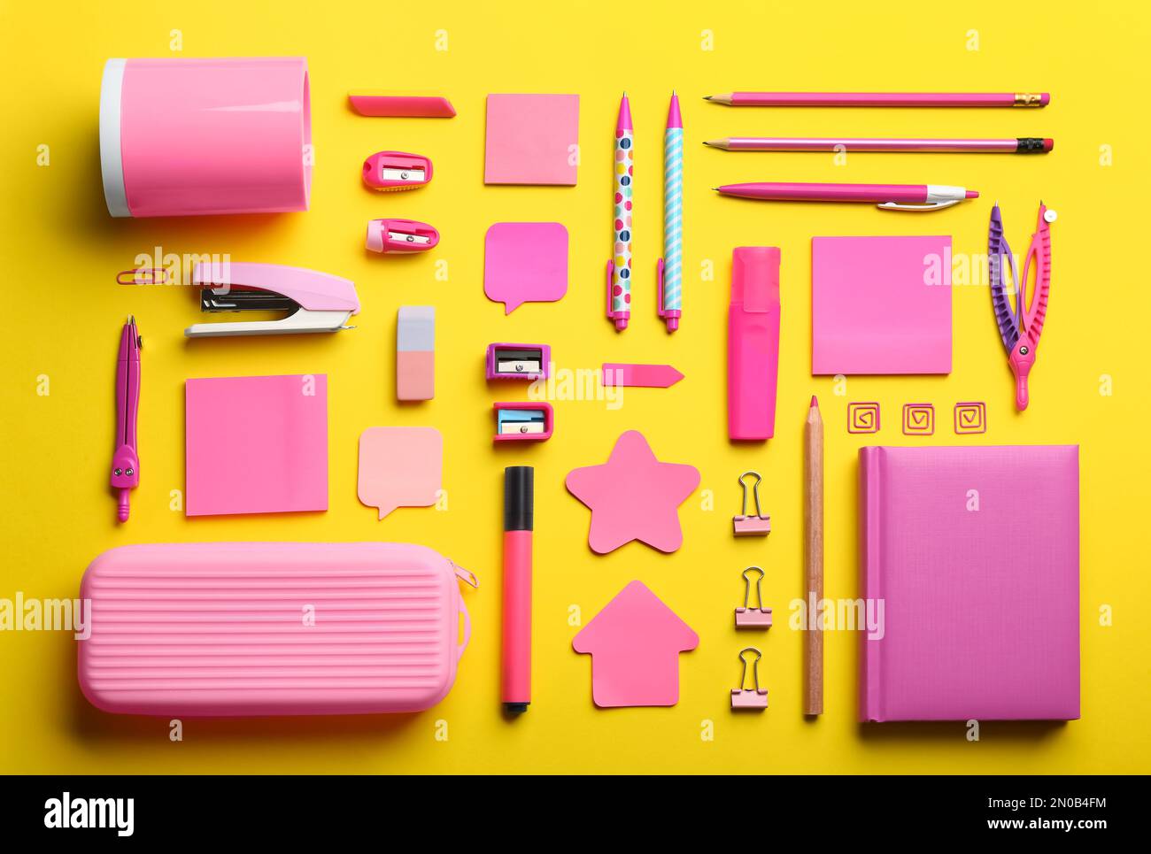 Flat lay composition with pink school stationery on yellow background ...