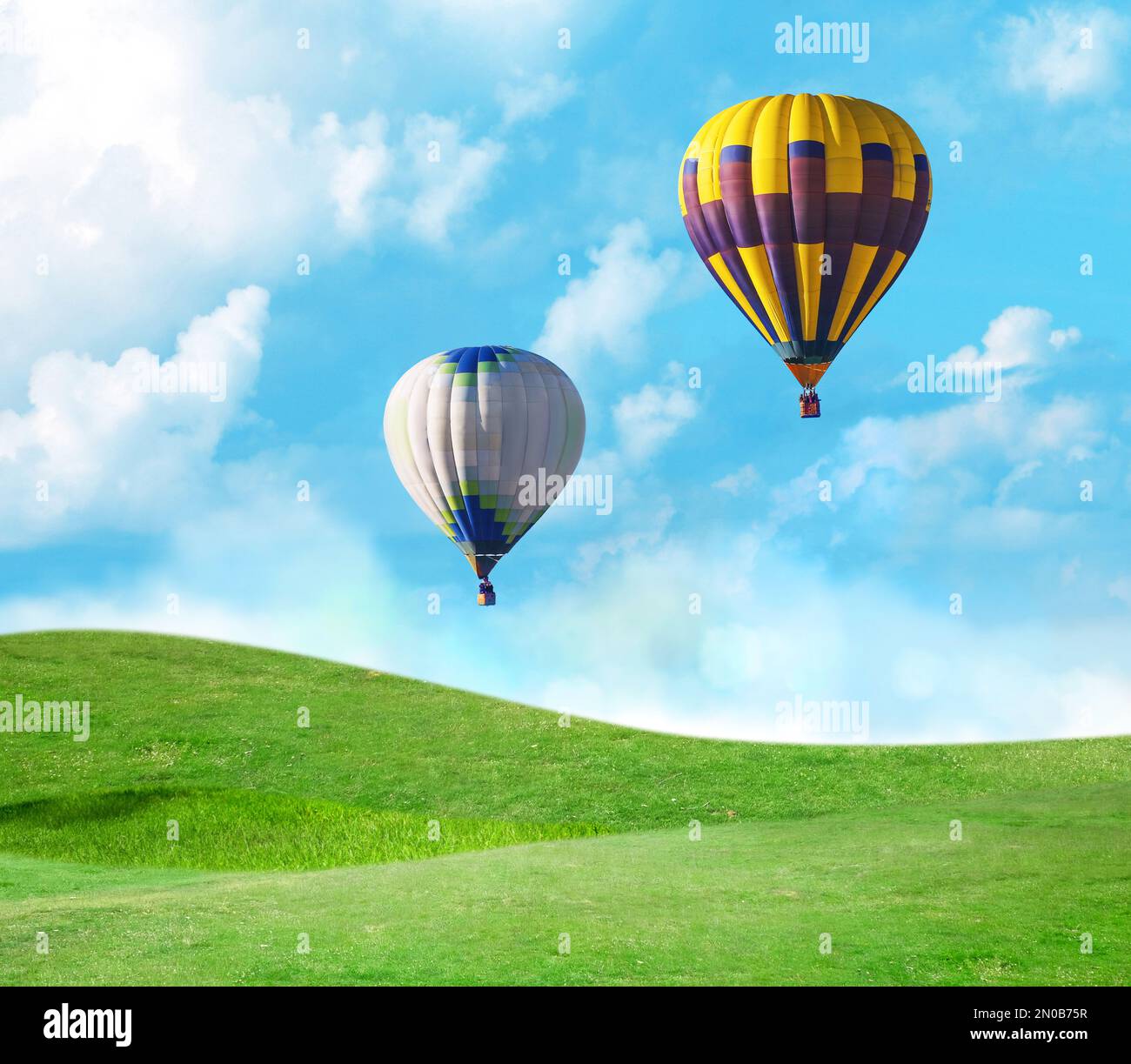 Fantastic dreams. Hot air balloons in blue sky with clouds over green