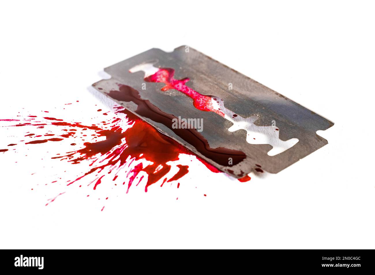 Razor blade wit blood splash and blood drops, isolated on white, selective focus macro. suicide concept Stock Photo