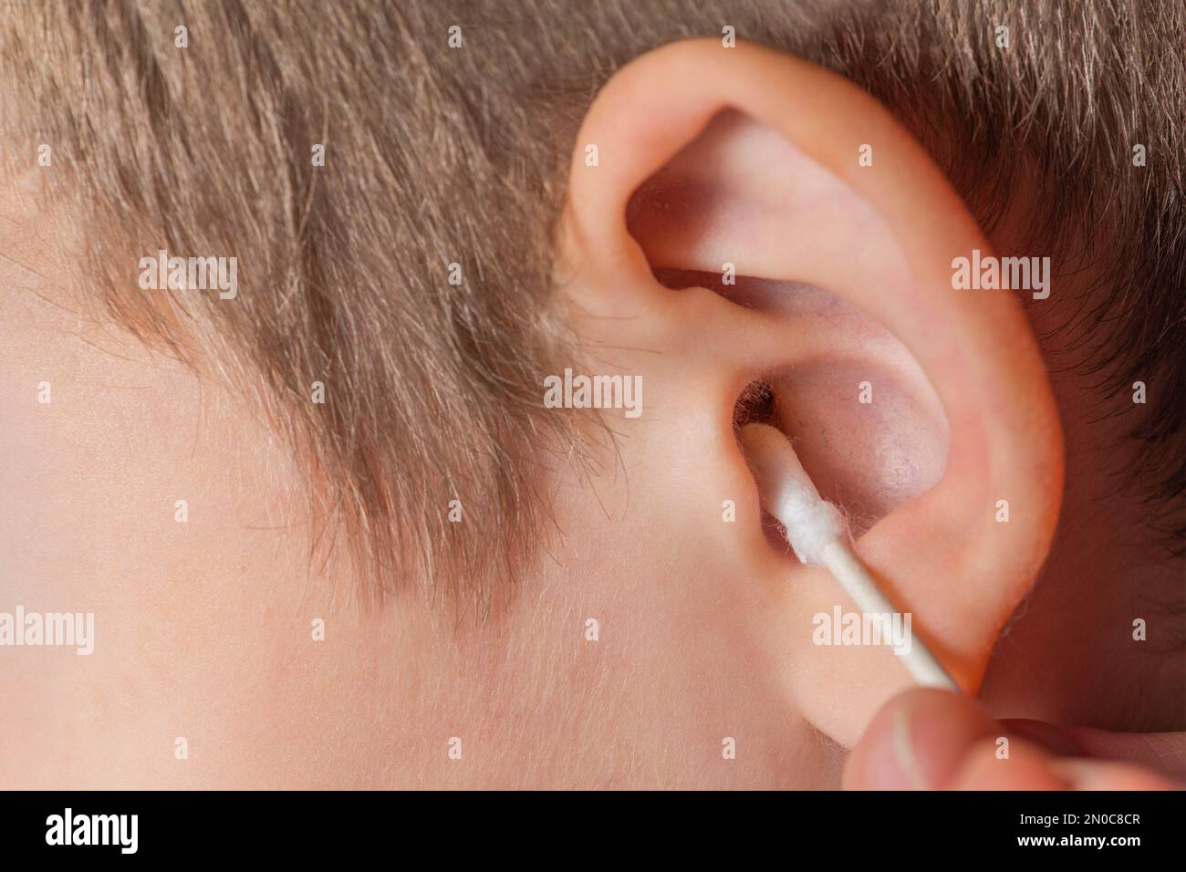 Cleaning the ear with a cotton swab. The process of cleaning the ears