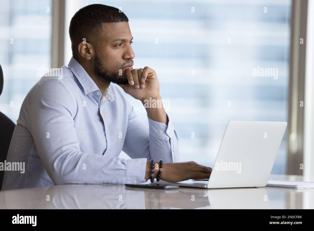 Thoughtful young African office worker thinking over career problems Stock Photo