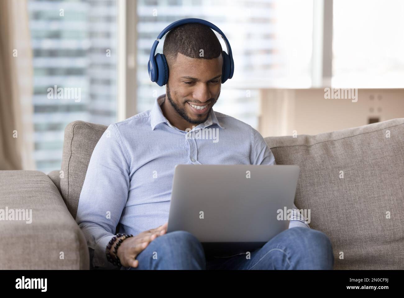 Happy millennial Black freelancer man using laptop computer Stock Photo
