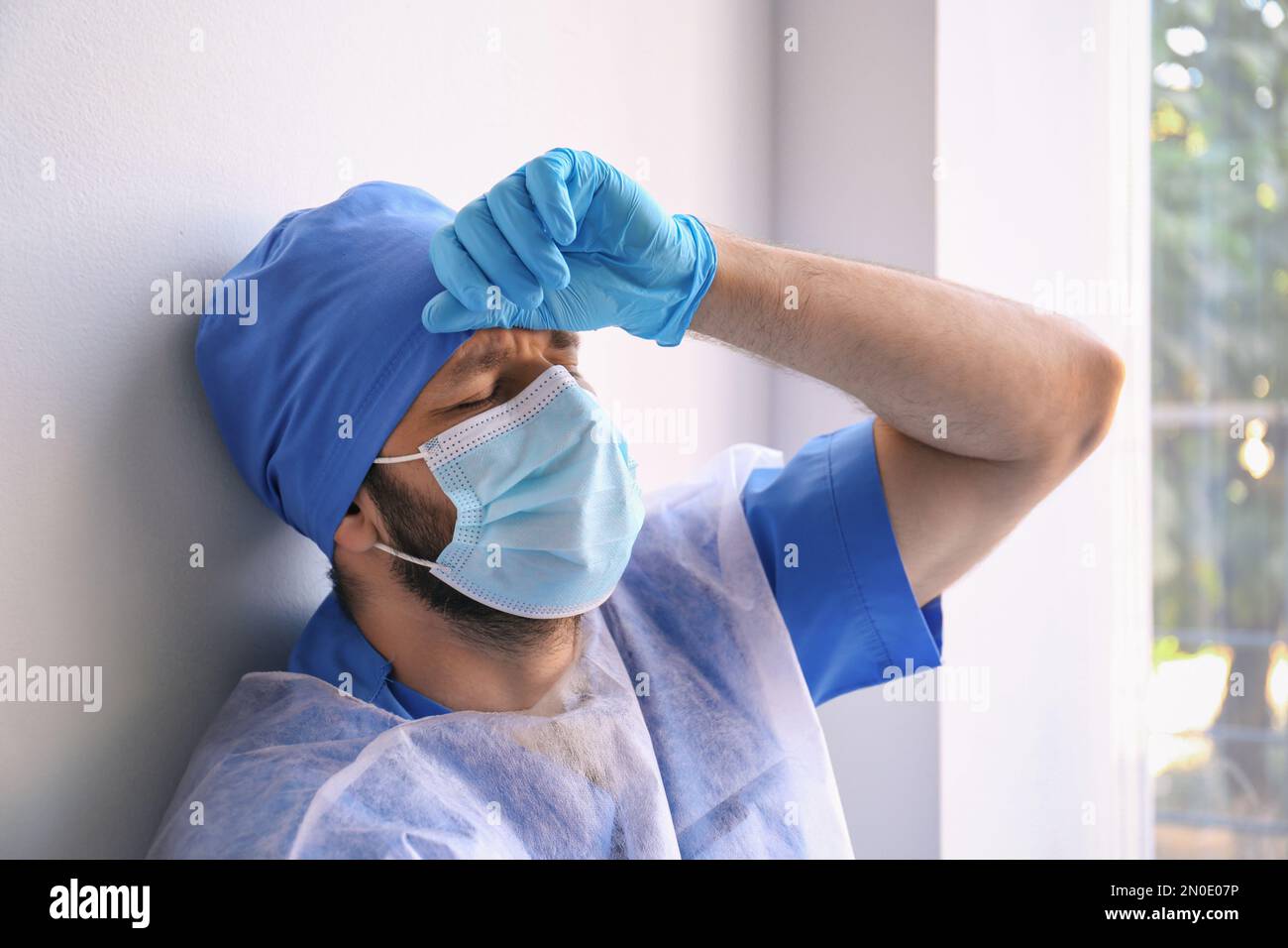 Exhausted Doctor Near Window Indoors Stress Of Health Care Workers